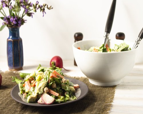 Healthy colorful salad bowl with fresh vegetables on white table